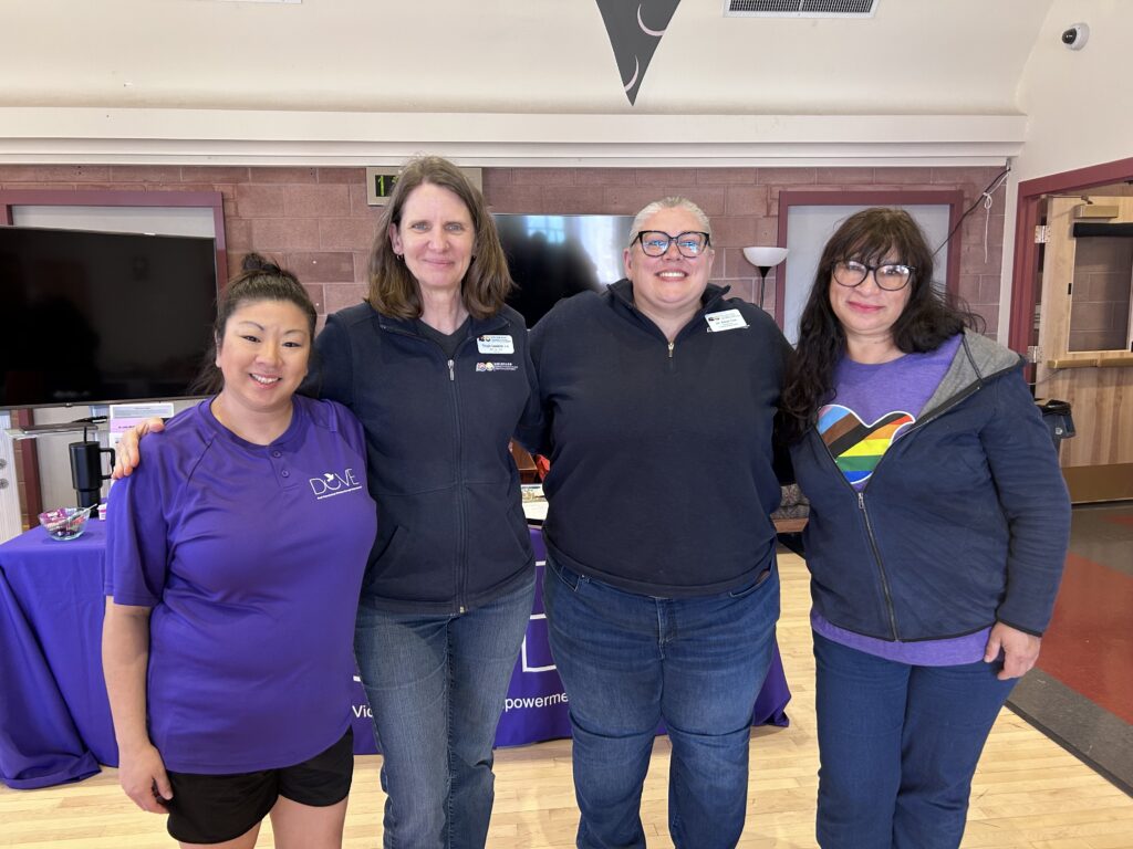 Group of staff standing together and smiling at a workplace event